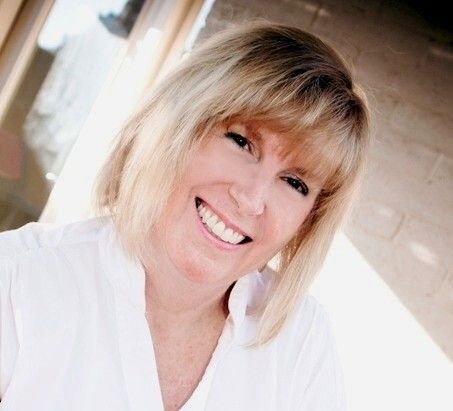 A smiling woman wearing a white shirt.